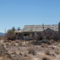 desert landscape with abandoned house in derelict field